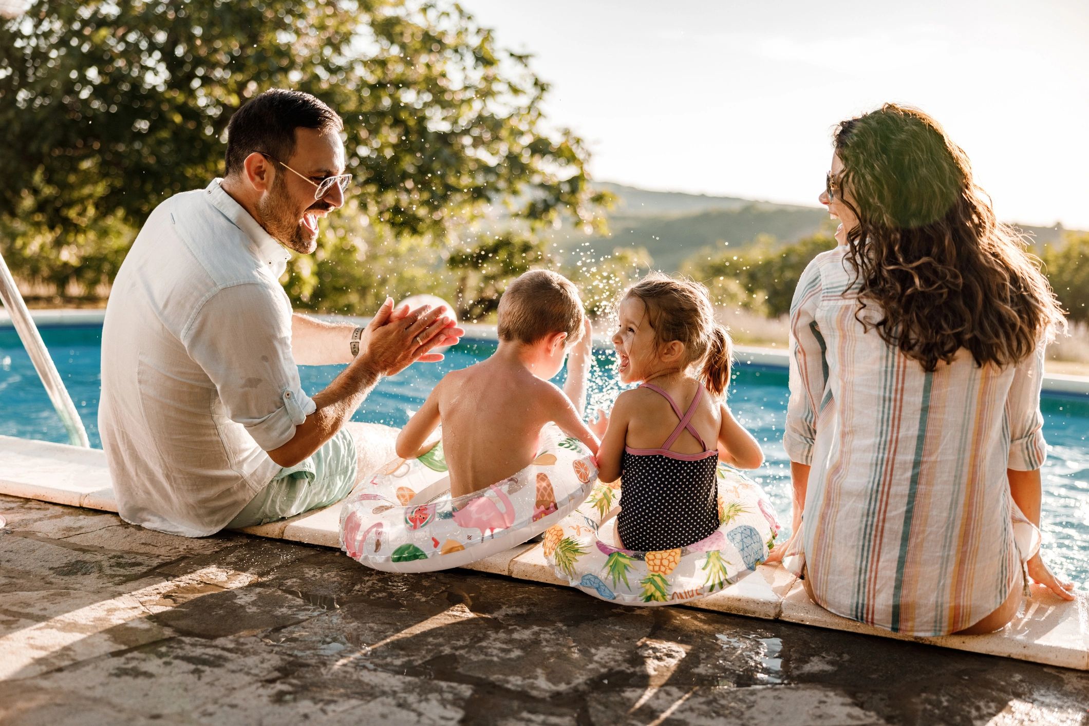 Family enjoying time by a backyard pool